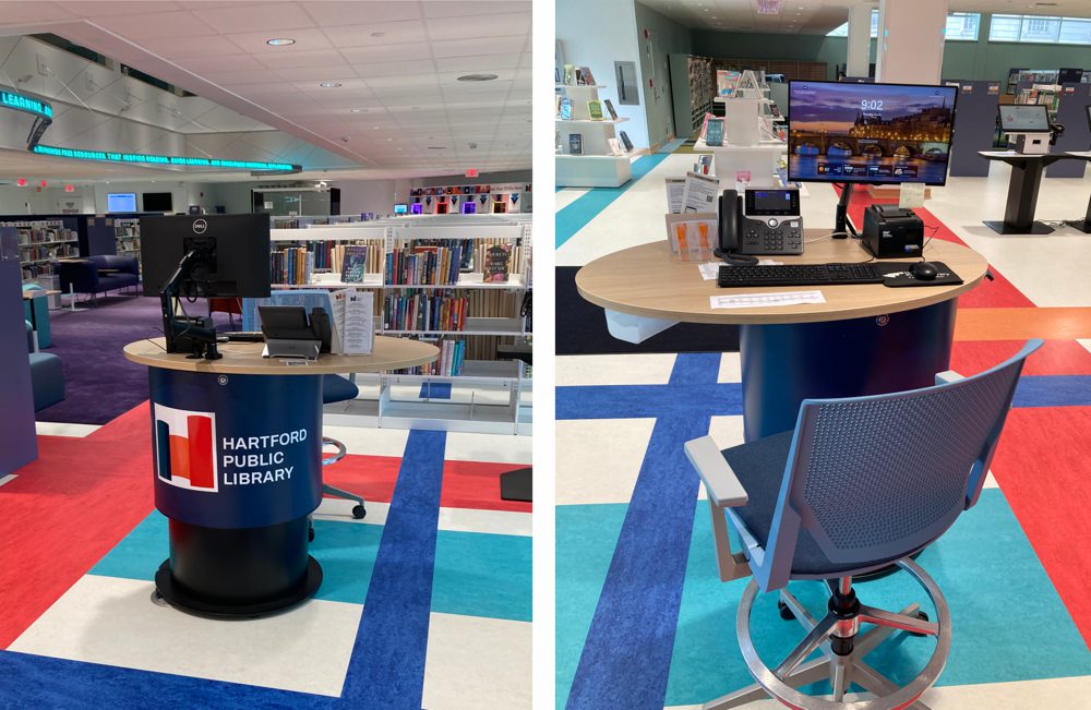 •AGED ASH worktops contrast gracefully with the smart and on-brand NAVY BLUE upper desk frontages. • BLACK lower frontages on all desks were a great choice for visual cohesion. • Brushed stainless steel kickers, available as an upgrade, elevate the look of the central circulation counter, delivering a refined, contemporary finish. • Signage featuring Hartford Public Library’s logo was applied to the desk frontages, connecting the service points to the Library branding and interiors while making them easy to identify for patrons. • Pop Spot Pencil Drawers provide the 101 Pods with a small amount of storage. • All the desks are fitted with our range of ATDEC Monitor Arms.