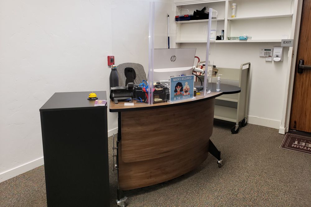 A second desk was positioned at the far end of the hall, providing another designated area for customer service - Harrison Memorial Library; Carmel-by-the-Sea.