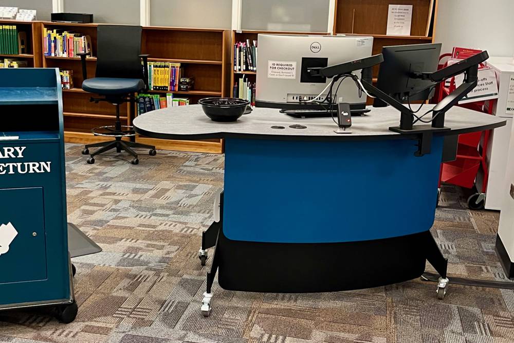 A YAKETY YAK 203 Desk creates an additional flexible workspace adjacent to the main library help desk at the University of North Carolina Library.